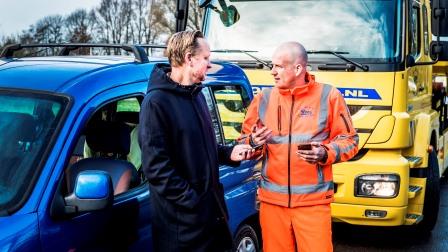 man praat met chauffeur van sleepdienst