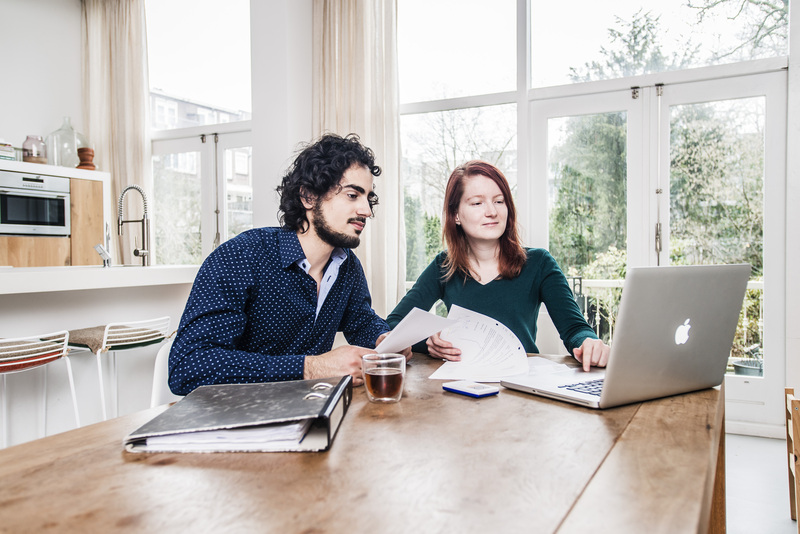 stel zit aan tafel met een macbook