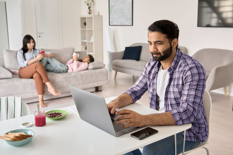 man aan tafel werkt op laptop